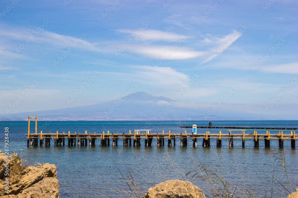 Brucoli seascape looking at Etna from the port, wooden pier in the blue sea, clear colours
