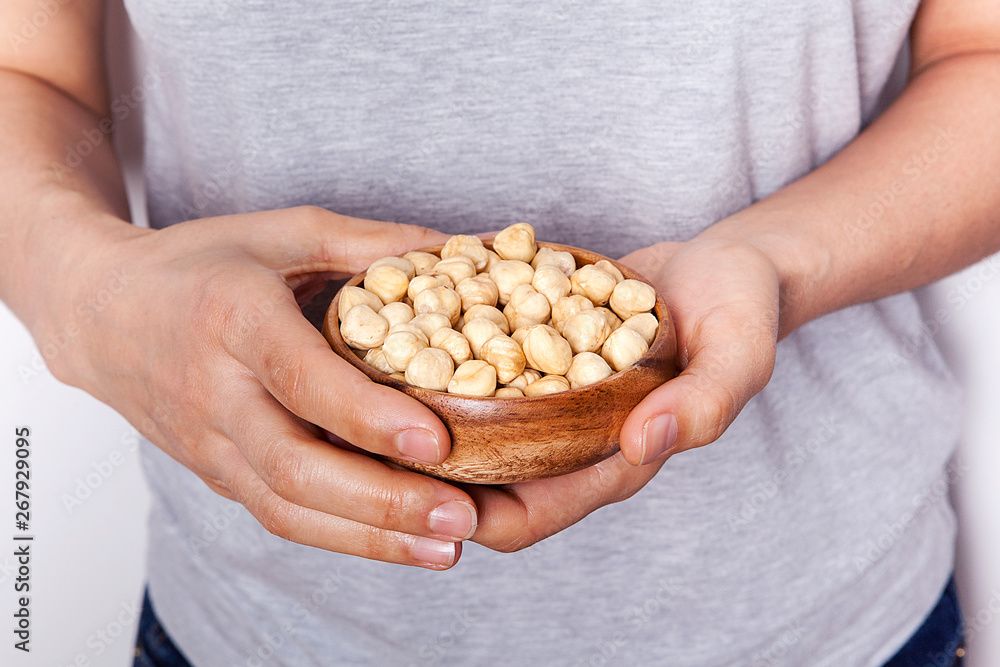 Woman's in hand hazelnut in a bowls. Healthy food and snack. Woman's in hand hazelnut in a bowls. Healthy food and snack.