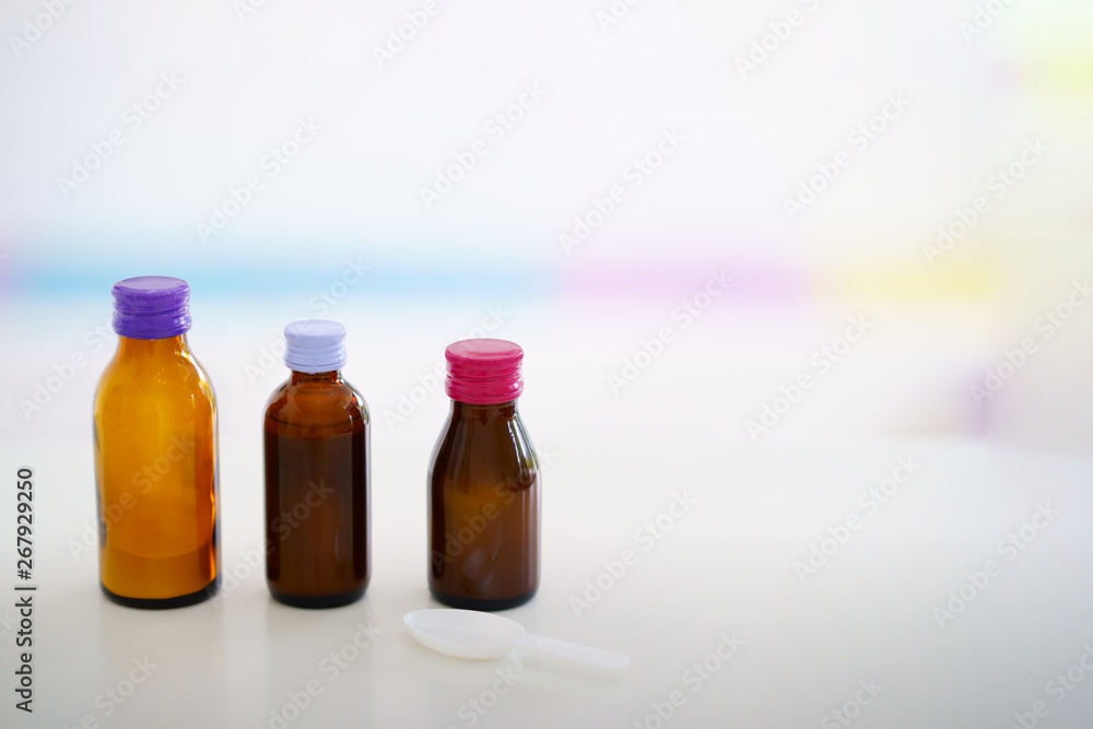 Glass drug bottles with colorful caps on blur background Glass drug bottles with colorful caps on blur background