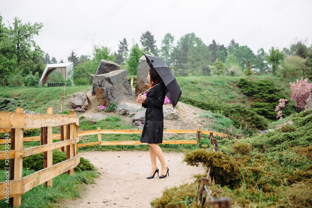 woman walking in the park with umbrella