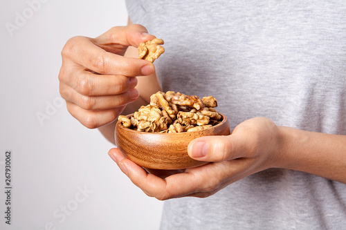 Woman's in hand walnut in a bowls. Healthy food and snack.