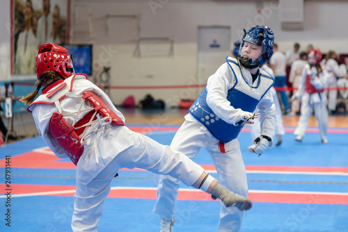  two girls in blue and red Taekwondo equipment are fighting at doyang photo