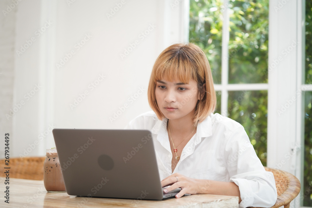 Asian businesswoman working on laptop in her workstation with tension. Asian businesswoman working on laptop in her workstation with tension.