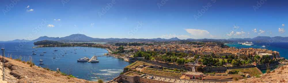 View of the ancient town on peninsula in to the crystal clear azure sea from Old Fortress of Corfu Town. Kerkyra, capital of Corfu island. Greece. 