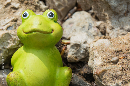 Decorative frog in the garden. Ceramic figurine of a green frog