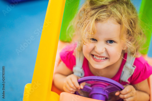Little girl rides a toy colorful car