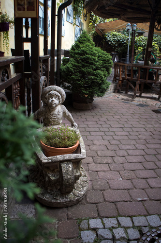 Stone sculpture of a boy carrying a cart in the courtyard of a residential building photo