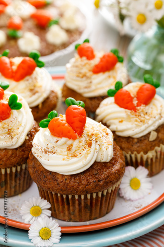 Carrot cupcakes with mascarpone cream decorated with marzipan carrots on a plate. Delicious homemade dessert