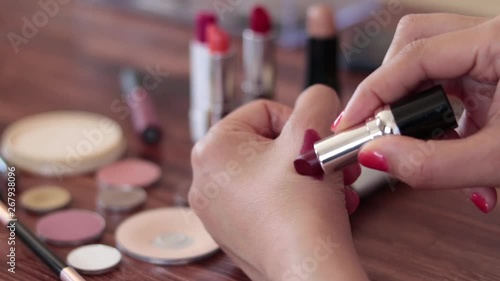 Woman testing lipstick color on her hand