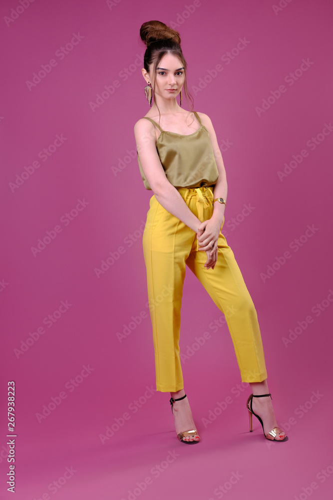 Portrait of fashionable young woman dressed in yellow pants Portrait of fashionable young woman dressed in yellow pants