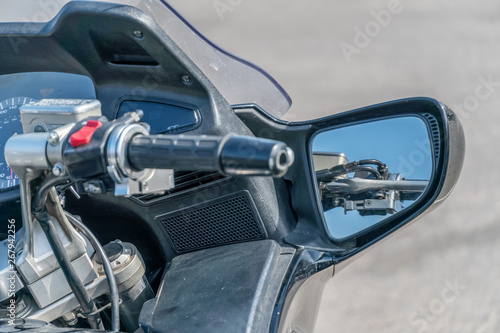 Beautiful and stylish control panel and steering wheel of a modern motorcycle at close range against the background of the city. © yaroslav1986