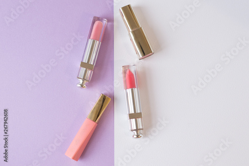 Decorative flat lay cosmetics lip gloss and lipstick. top view