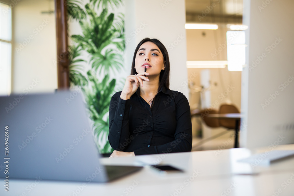 Beautiful business woman dreaming or thinking of new isea while working on computer at her office Beautiful business woman dreaming or thinking of new isea while working on computer at her office