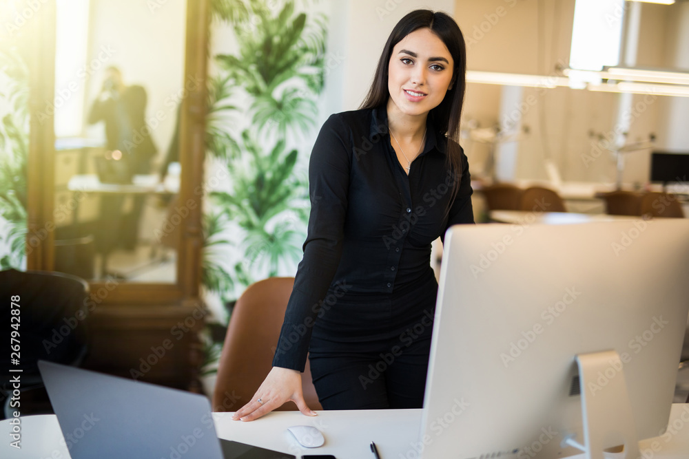 Attractive young business woman working on laptop at office. Business people.