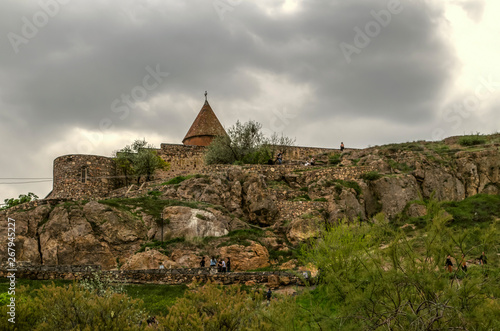 Khor Virap fortress with the visible dome of the Church of the blessed virgin on a rocky hill in the Ararat valley against the darkened sky