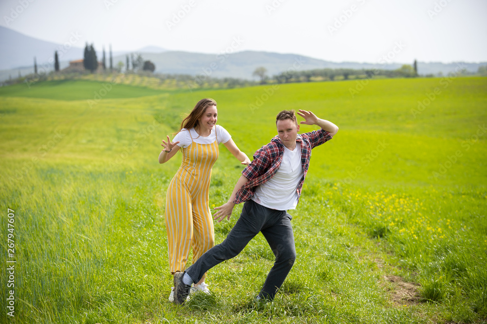A young funny couple standing on a green meadow A young funny couple standing on a green meadow