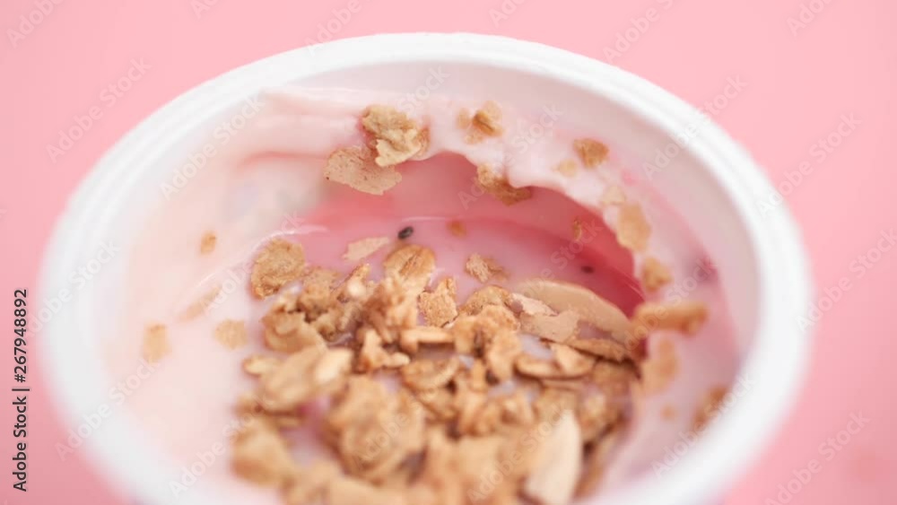 Sprinkling whole grains and almond sliced in yogurt bowl, slow motion. Sprinkling whole grains and almond sliced in yogurt bowl, slow motion.