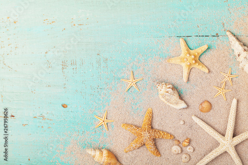 Starfishes and seashells on sand for summer holidays and travel background.