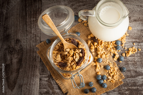 Healthy breakfast concept with oat flakes and fresh berries on rustic background. Food made of granola and muesli. Healthy banana smoothie with blackberries, honey and milk.