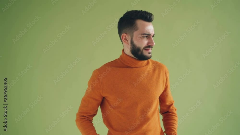 Disgusted guy is showing thumbs-down gesture shaking hands and wrinkling face expressing negative attitude. Unhappy people, dislike and emotions concept. Disgusted guy is showing thumbs-down gesture shaking hands and wrinkling face expressing negative attitude. Unhappy people, dislike and emotions concept.