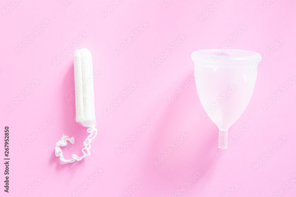 Zero waste concept - menstrual cup as alternative to tampons and traditional female hygiene, pink background