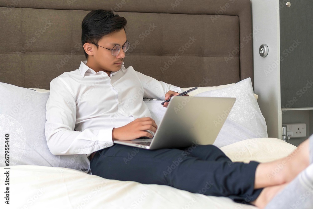 Young Malay Muslim working with laptop at the bed Young Malay Muslim working with laptop at the bed