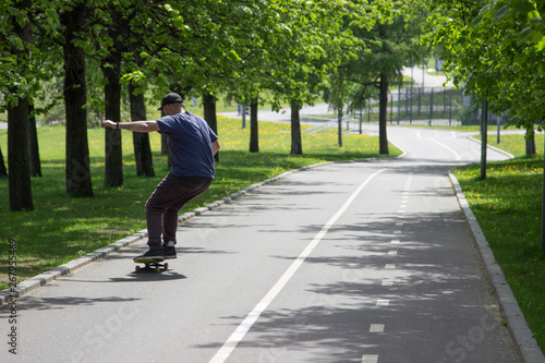 Man, skater rides down a hill on a skateboard in a park on a track. Skateboarding, Longboarding.