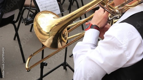 Man musician play trombone in municipal orchestra performing at festive concert open air.