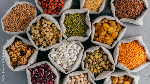 Fotografie Various grains and dried fruit in hessian bags on market stall