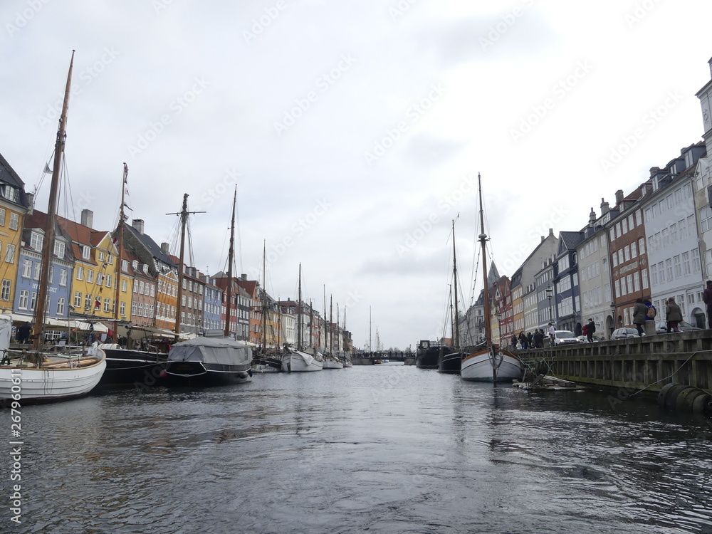 Fototapeta premium COPENHAGEN, DENMARK - MARCH 2019: View of Nyhavn. Boats stand on the Nyhavn pier in the city center.