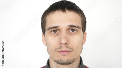Portrait of young attractive upset man looking at the camera on a white background.