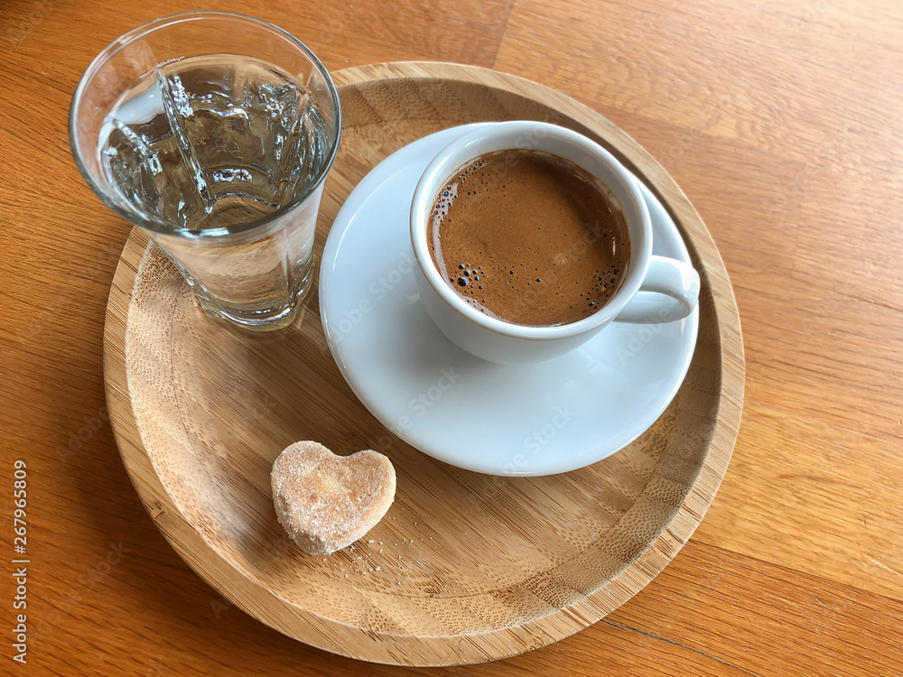 Turkish coffee and water served with a cookie Turkish coffee and water served with a cookie
