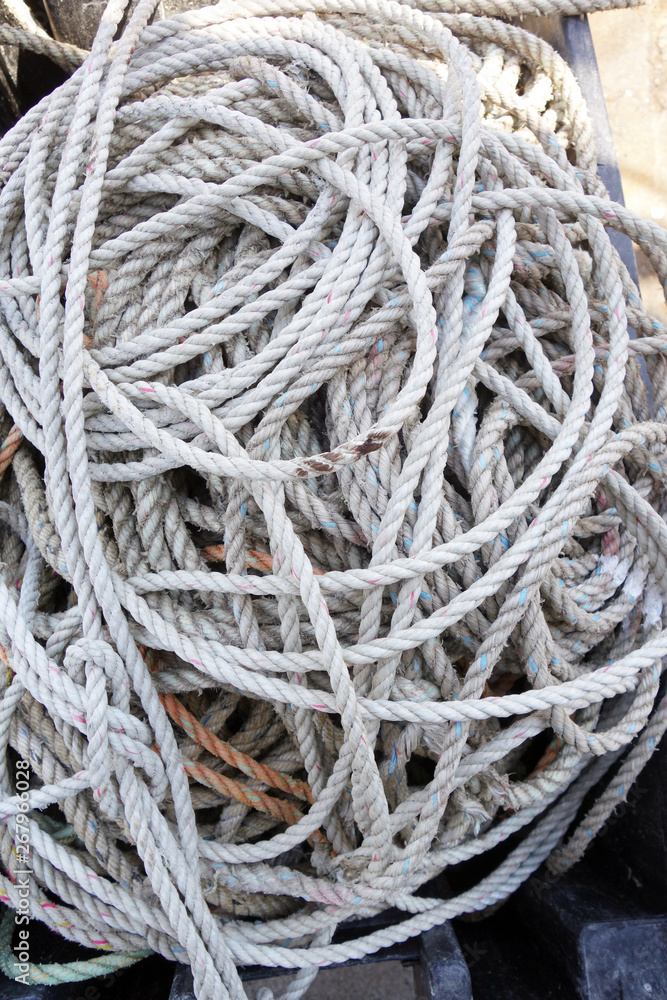 coils of used and grungy white nylon lobster trap rope Vertical