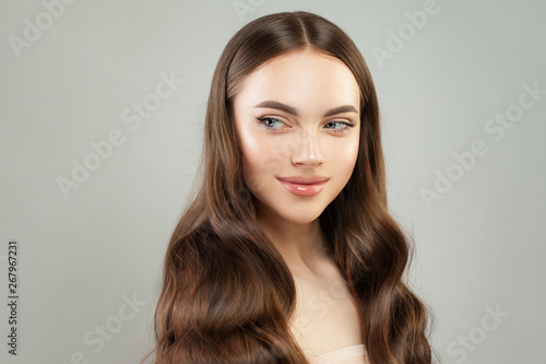 Attractive young woman smiling and looking aside. Girl with clear skin and perfect hair