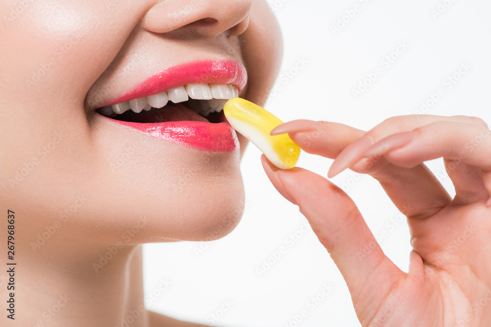 cropped view of cheerful woman eating jelly candy isolated on white cropped view of cheerful woman eating jelly candy isolated on white