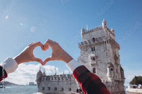 love lisbon I love Portugal. Symbol of Portugal. The symbol of Lisbon. A girl holds hands in the shape of a heart on the background of the symbol of Portugal. Torre di Belém. Sunny portuguese weather. photo