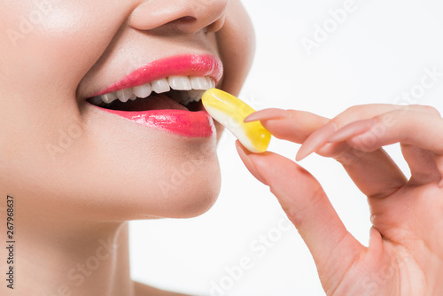 cropped view of cheerful woman eating jelly candy isolated on white