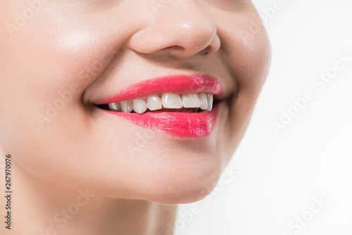 cropped view of young woman with pink lips smiling isolated on white