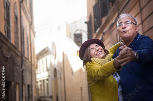 coppia di anziani balla felice in mezzo a una strada photo