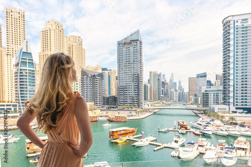 Woman in Dubai Marina, United Arab Emirates. Attractive lady wearing a long dress admiring Marina daylight views photo