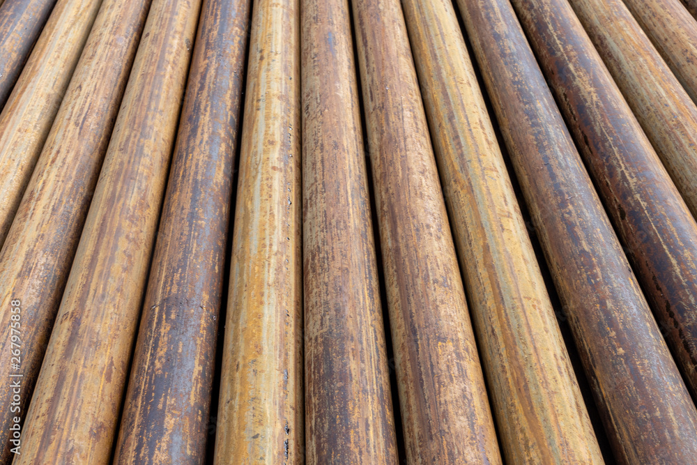 Rusty grunge pipes horizontal background. Orange corrosion rust on steel metal factory industrial pattern. Rough texture brown parallel stack close up Rusty grunge pipes horizontal background. Orange corrosion rust on steel metal factory industrial pattern. Rough texture brown parallel stack close up
