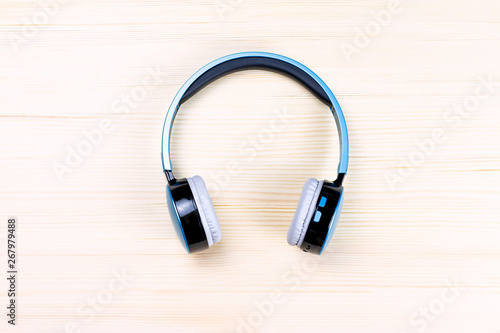 Blue wireless headphones close up on wooden background