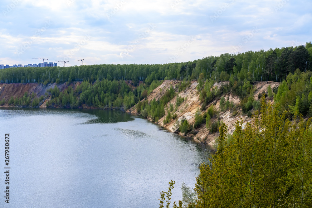 Sand quarry by the river on the outskirts of the city