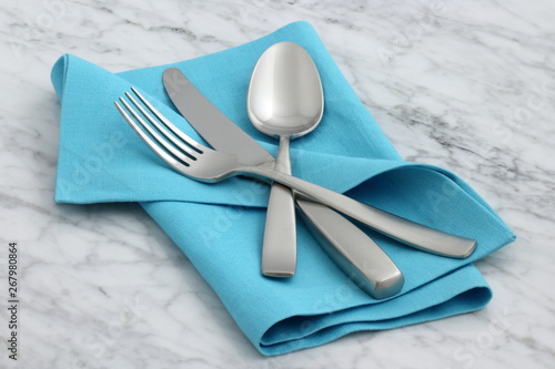 silverware and hemstitch napkin on antique carrara marble photo