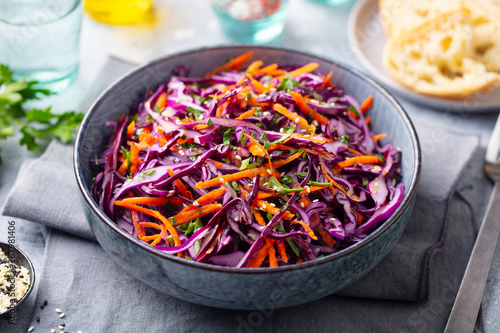 Fotografie Red cabbage salad, Coleslaw in a bowl. Grey background. Close up.
