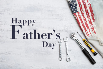 Happy Father's day with metal tools and American flag on white texture background