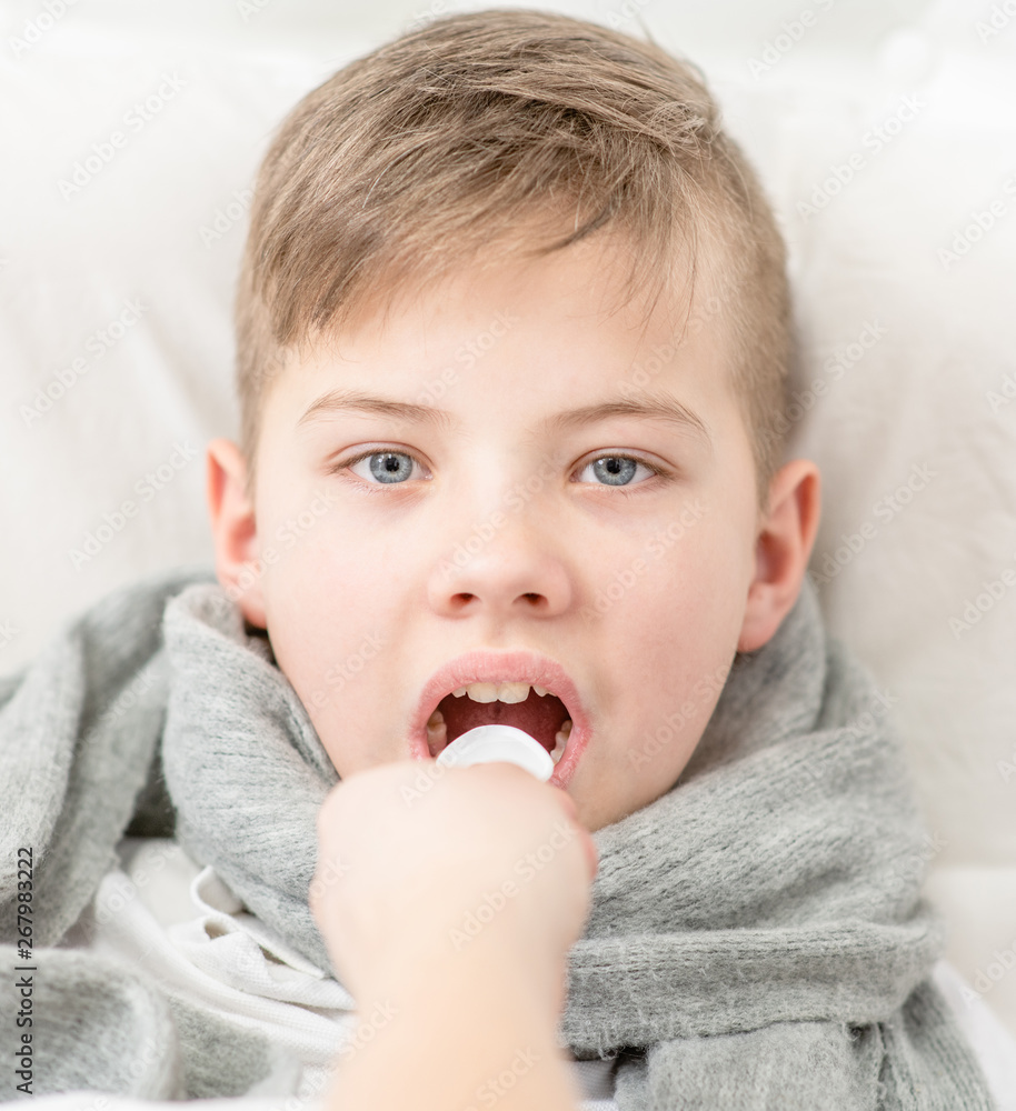Sick little boy take medication pouring in a spoon. Looking at camera Sick little boy take medication pouring in a spoon. Looking at camera