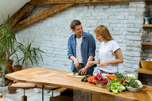Lovely cheerful couple cook...