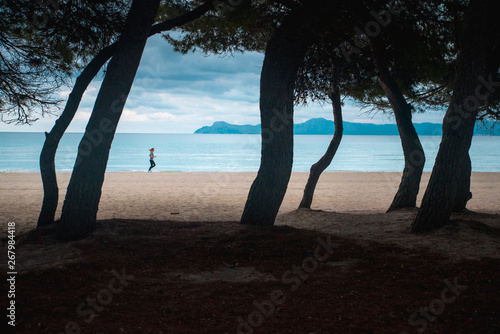 Woman run on the morning beach even in rainy weather. Motivation sport photo