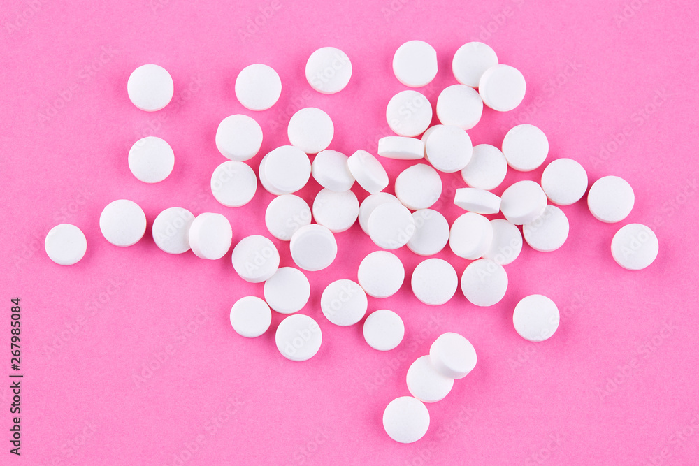 Heap of white pills on pink background Heap of white pills on pink background